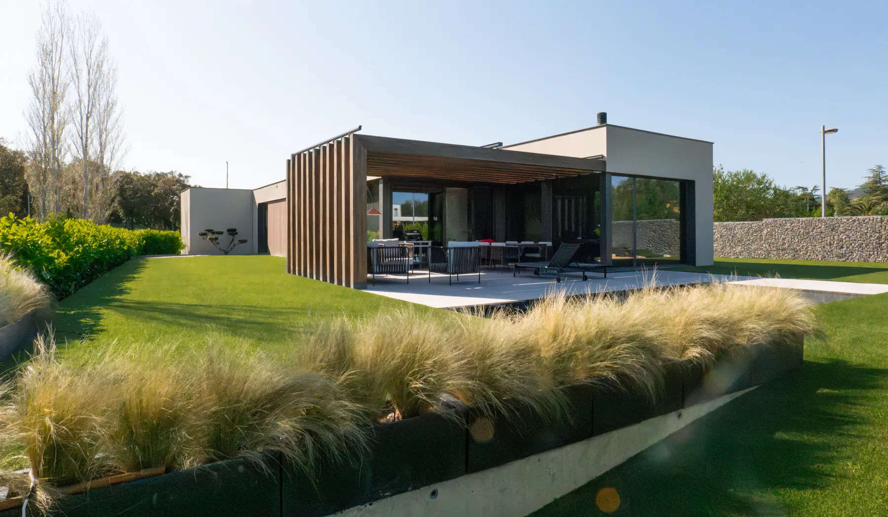 Jardín residencial mantenido con césped y vegetación consolidada